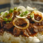 A Yoshinoya Beef Bowl served on a ceramic plate, featuring thinly sliced beef and onions over white rice, with a warm and inviting presentation